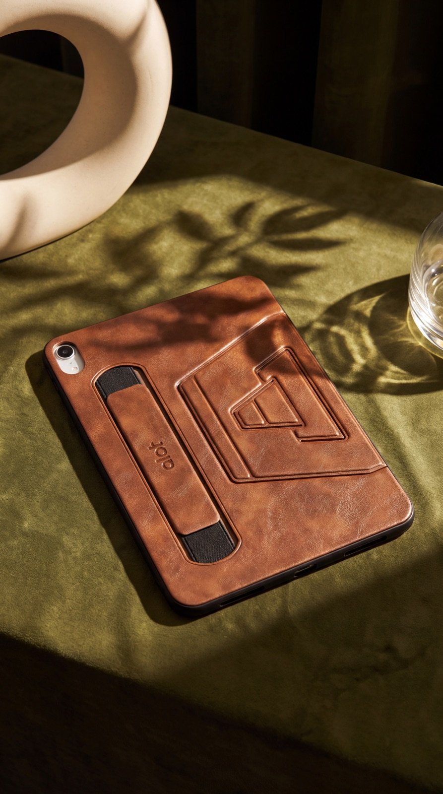 ALOT’s brown leather iPad case on a green table