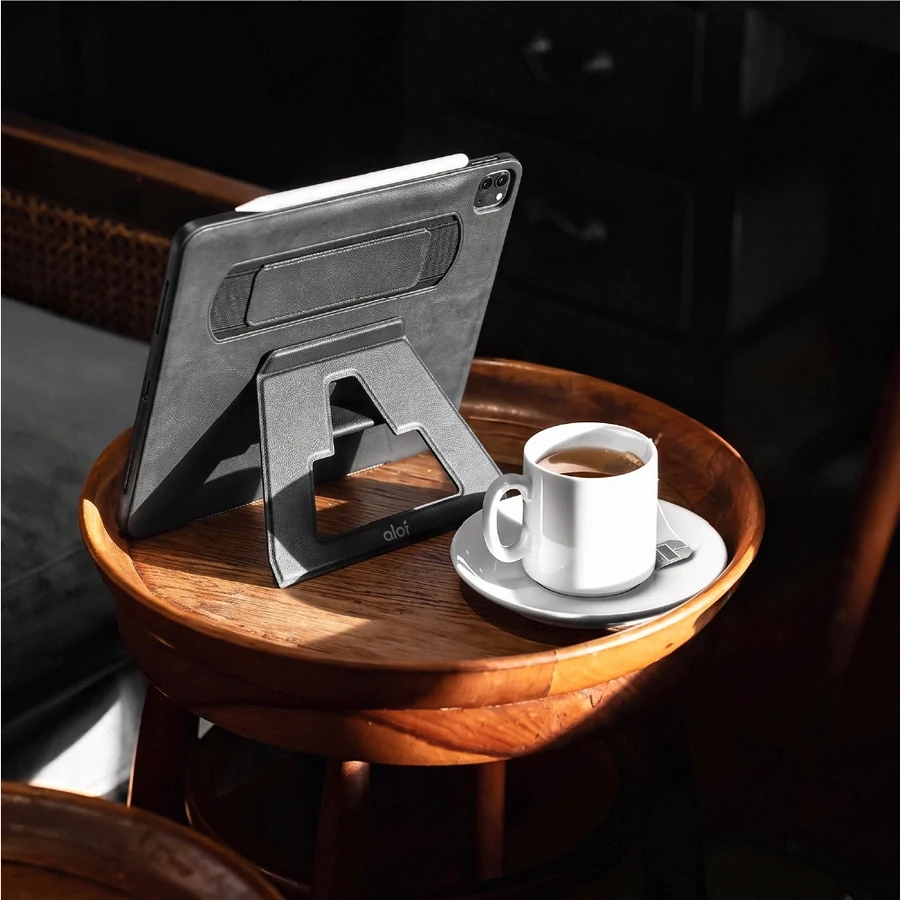 An iPad in its ALOT case, propped beside a cup