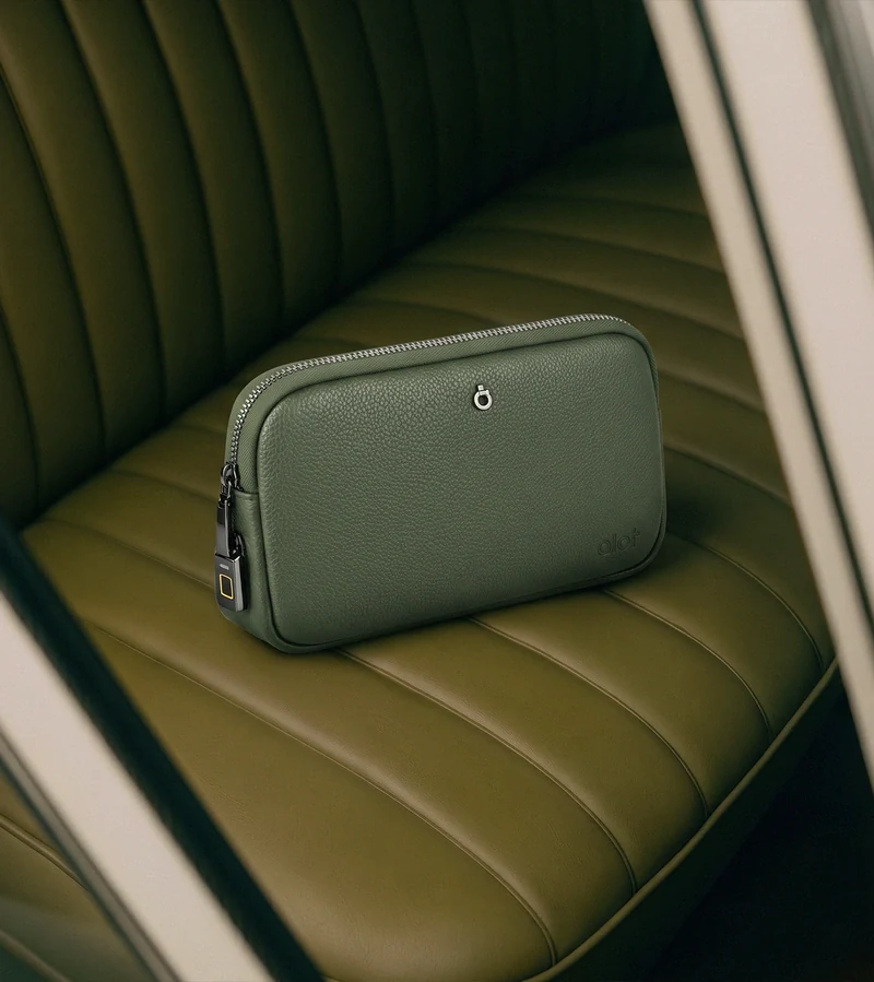 An ALOT pouch on a green leather seat
